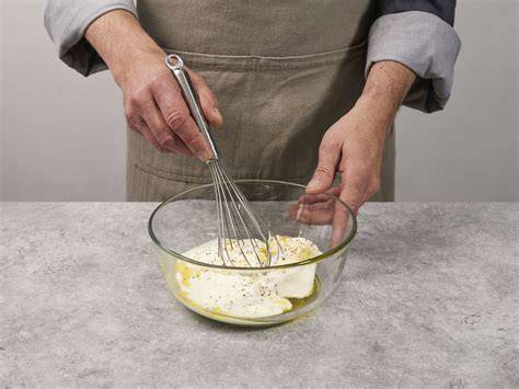 Zubereiten und Abschmecken einer Schmandcreme mit Anrühren von Honig und Puderzucker