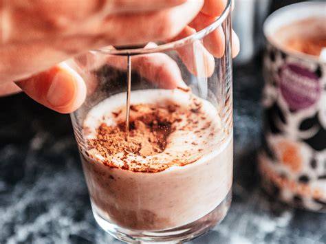 Zubereitung eines Kakao-Cappuccinos mit Espressoshot und Milchschaum