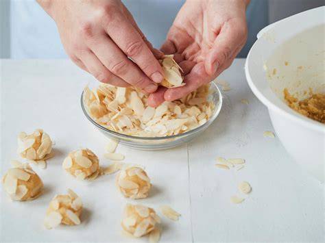 Zubereitungsschritte für Mandorlini: Formen, Wälzen in Mandeln, Backen