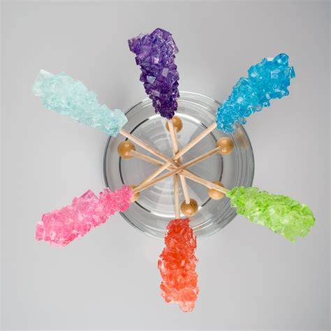 Zuckerkristalle auf Stäbchen und bunte Glasgefäße