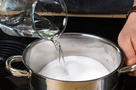 Zuckersirup im Kochtopf und abgeschöpfter Schaum