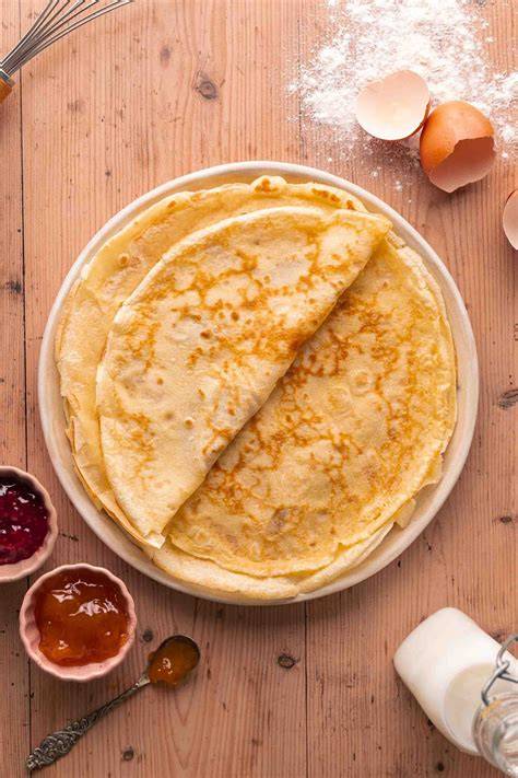 Zutaten für Crêpes-Teig angeordnet auf einem Tisch