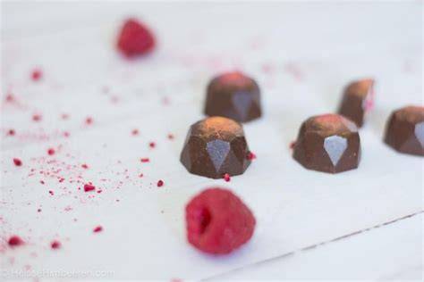 Zutaten für Himbeer-Trüffel-Pralinen: Schokolade, Himbeeren, Hohlkörper und Dekoration