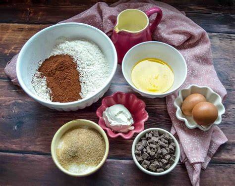 Zutaten für Schoko Muffins einzeln dargestellt (Mehl, Kakao, Zucker, Eier, Öl, Schokolade, Milch)