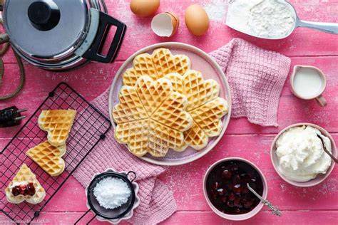 Zutaten für klassischen Waffelteig hübsch angeordnet auf einer rustikalen Küchenplatte