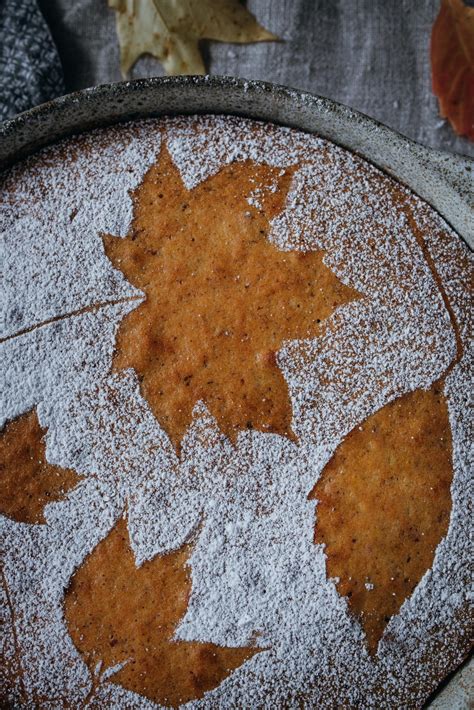 Zutaten und fertiger Chai-Tee-Kuchen, dekoriert mit Puderzucker und Blättern