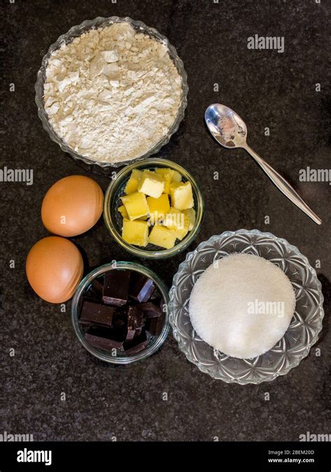 Zutaten wie Butter, Eier, Mehl und Schokolade auf einem Backbrett angerichtet