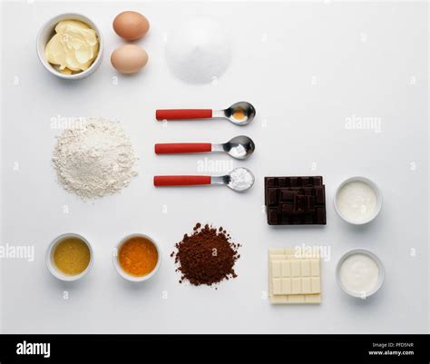Zutaten-Flatlay: Eier, Mehl, Schokolade, Sahne, Birnen, Tortentools