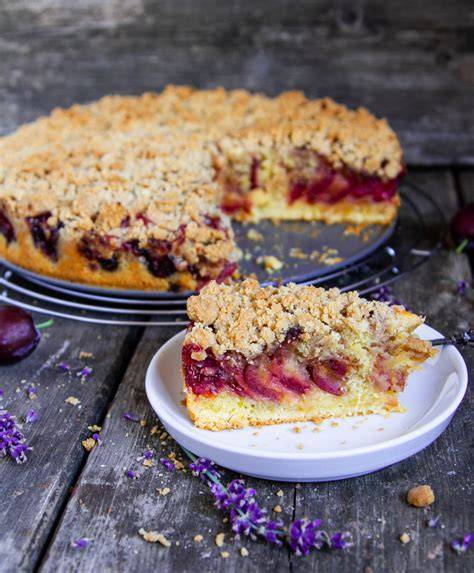 Zwetschgen Streuselkuchen angerichtet auf einer rustikalen Holzplatte mit Thermomix im Hintergrund