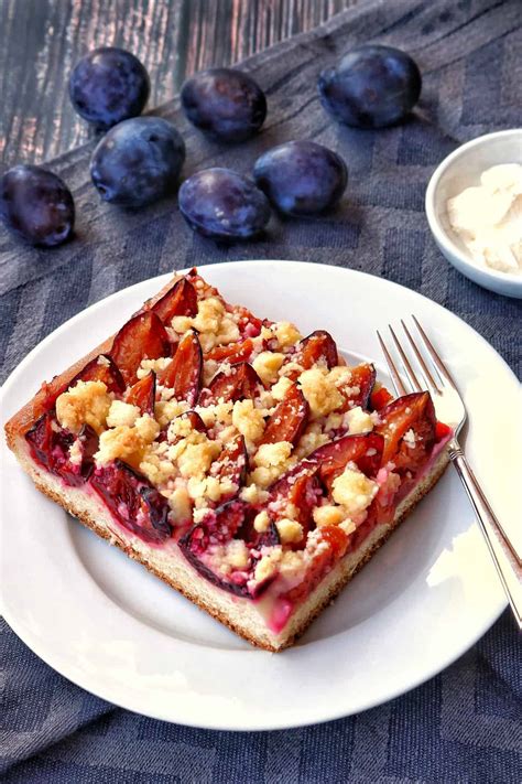 Zwetschgenkuchen mit Streuseln, Zimtzucker und Schlagsahne serviert