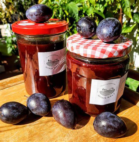 Zwetschgenmarmelade im Glas mit Zwetschgen und Marzipan daneben
