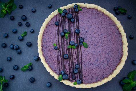 angeteilte Blueberry Cheesecake Tarte mit Minze garniert