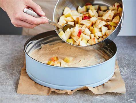 auf den Mürbeteig verteilte Apfelstücke auf einem Backblech