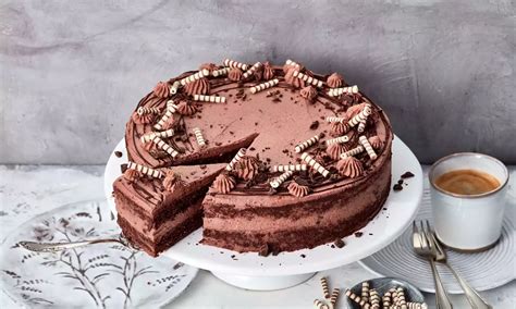 dekorierte laktosefreie schokotorte mit schokospänen und sahnetuffs