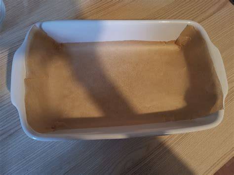 eckige Auflaufform mit Backpapier und Zutaten