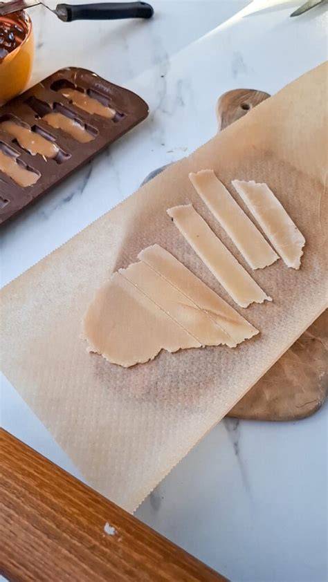 eingewickeltes eingefärbtes Marzipan zwischen Backpapier