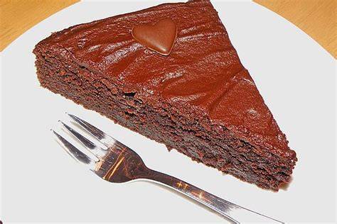 einzelnes Stück Schokoladenkuchen mit Puddingfüllung, angerichtet auf einem Kuchenteller