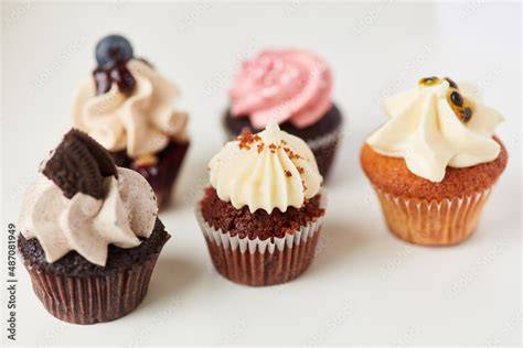 fertige cupcakes auf tortengitter mit unterschiedlichen toppings