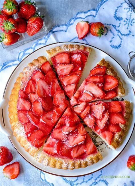 fertiger Erdbeerkuchen mit glänzendem Guss und Sahnetupfen