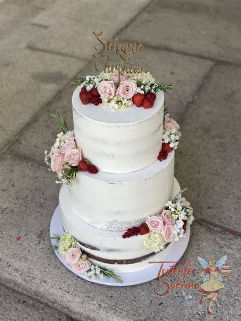 frisch dekorierte Hochzeitstorte mit Rosen und Beeren