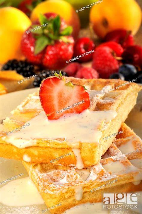 frisch gebackene, bunte Waffeln mit Vanillecreme und Früchten