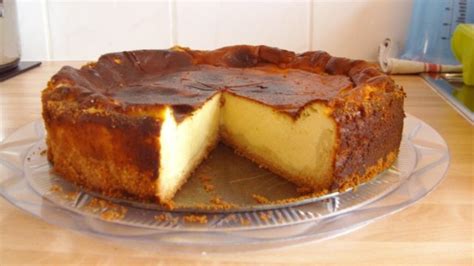 frisch gebackene Quarktorte ohne Boden, angeschnitten und dekoriert mit Puderzucker