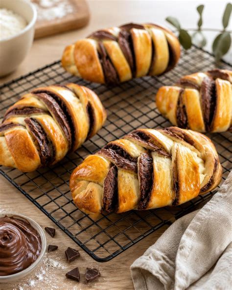 frisch gebackene Schokobrötchen auf einem Gitter, goldbraun glasiert