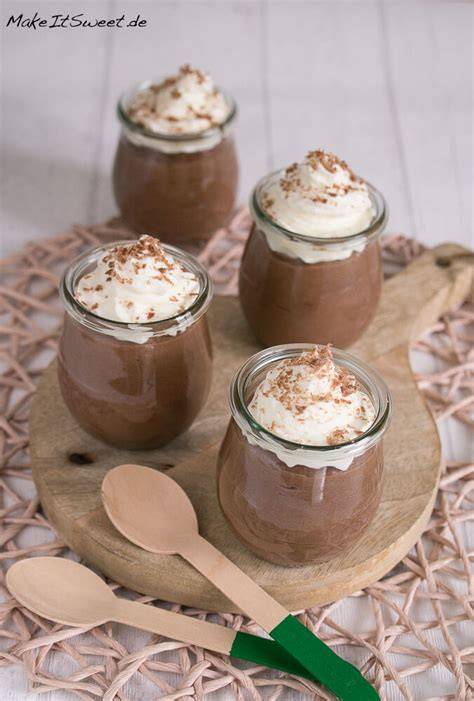 frische, selbstgemachte Schokoladensauce im Glas, daneben Zutaten wie Schokolade, Sahne und Kakao