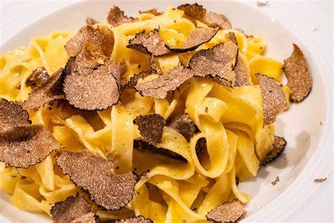 frische Pasta, weißer Trüffel und Trüffelhobel auf Küchentisch