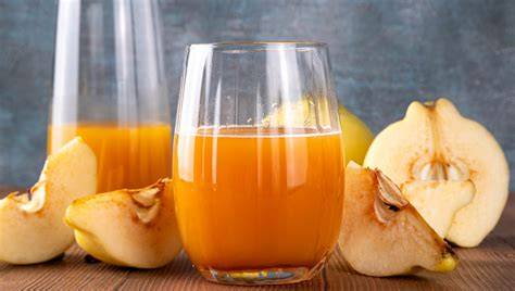 frische Quitten und Quittensaft in Gläsern