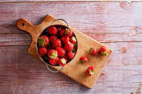 frische geschnittene erdbeeren und chili auf holzbrett