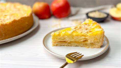 frischer Apfel-Schmand-Kuchen angeschnitten auf einem Backblech