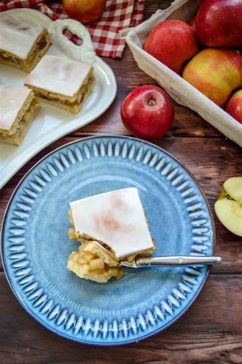 gedeckter Apfelkuchen mit Zuckerguss auf Kuchenplatte und Stücke für Gäste
