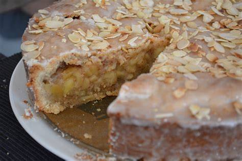 gedeckter apfelkuchen aufgedeckt, dekorativ, mit Mandelblättchen und Zuckerguss