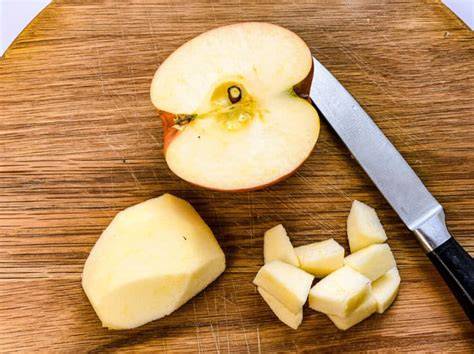 geschälte und geschnittene Äpfel mit Rosinen und Zimt in Schüssel
