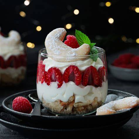 geschichtetes Dessert im Glas mit Vanillekipferl und Kirschen