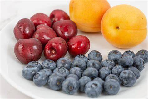 geschnittene Aprikosen und Heidelbeeren auf einem Tisch