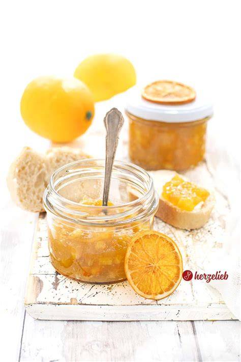 gläser mit orangemarmelade auf holzbrett