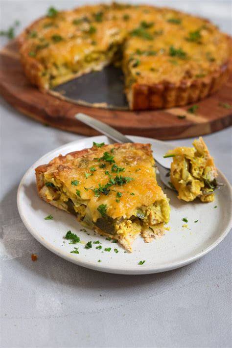 goldbraune Hack-Lauch-Quiche auf Holzbrett mit Salatbeilage