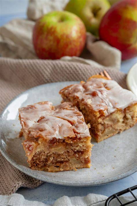 großes Stück Zimtschnecken Kuchen mit Apfel auf Teller