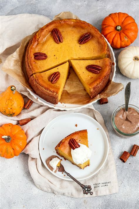 herbstlicher veganer kürbis käsekuchen, angerichtet mit saisonalen beeren und nuss-topping