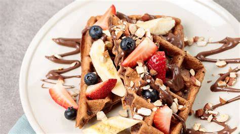 honigwaffeln mit schokosauce und frischen früchten angerichtet