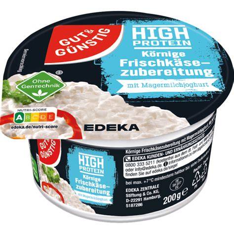 körniger Frischkäse im offenen Becher mit Löffel