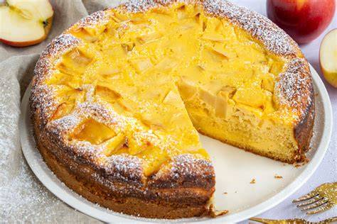klassischer Apfelkuchen mit saftigen Apfelstücken, auf einer rustikalen Holztafel angerichtet