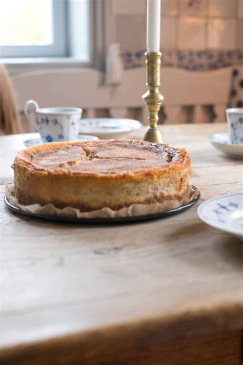 klassischer Rahmkuchen mit Zimtkruste und Porzellan auf gedeckter Kaffeetafel