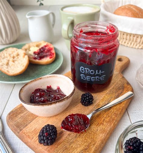 klassischer einkochvorgang brombeermarmelade im topf und gläser