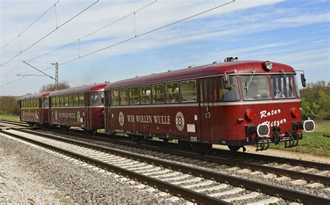 kleiner roter Flitzer mit Fahrer vor einer Stadtlandschaft