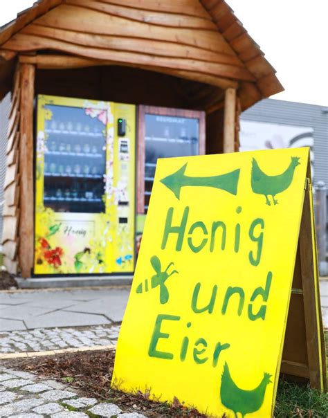 kleiner transportabler Honigautomat neben Hofeinfahrt
