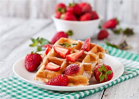 knusprige Milchmädchen Waffeln auf einem Teller mit frischen Erdbeeren