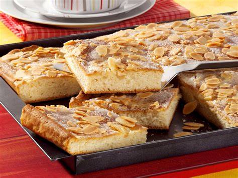 kuchen mit puderzuckerguss und mandeln